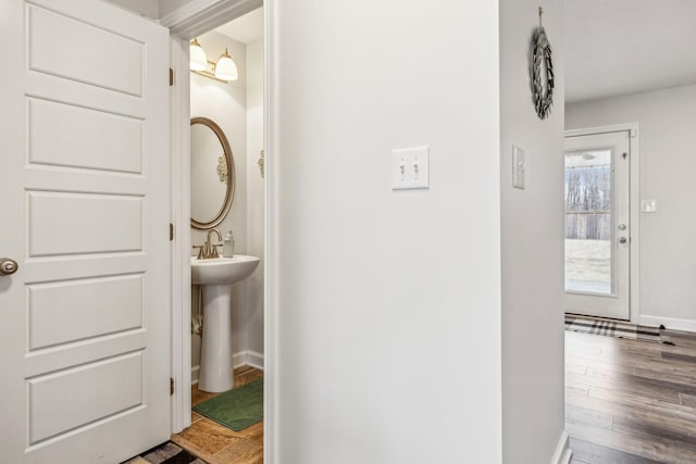 bathroom with a sink, wood finished floors, and baseboards