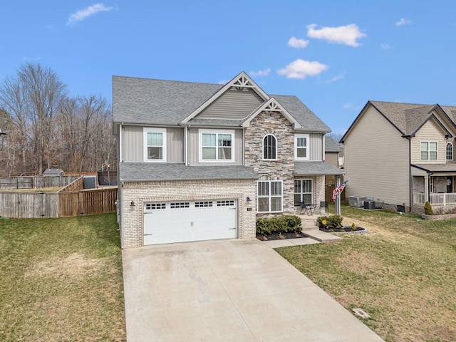 craftsman-style home with an attached garage, driveway, fence, and a front lawn