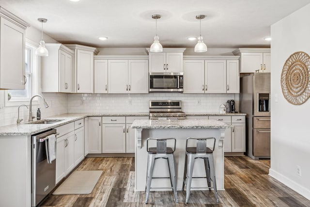 kitchen with stainless steel appliances, white cabinetry, a sink, and dark wood-style floors