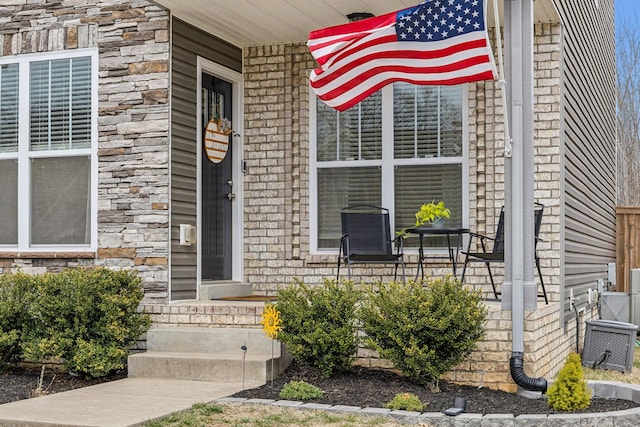 doorway to property featuring stone siding and covered porch