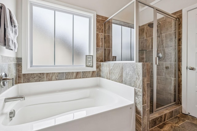 bathroom with a shower stall and a bath