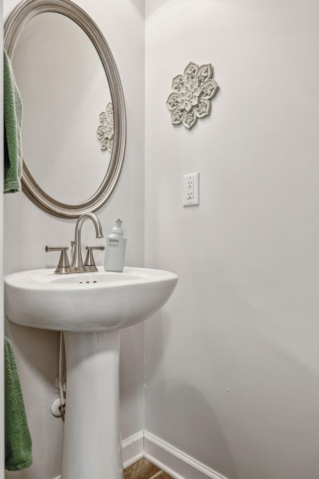 bathroom with a sink and baseboards