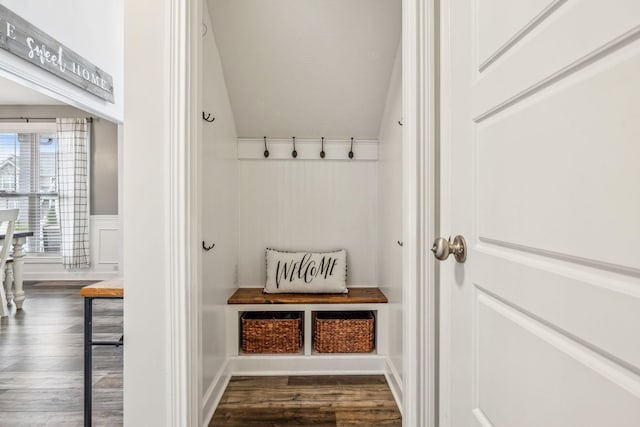 mudroom with lofted ceiling, dark wood-type flooring, a textured ceiling, and wainscoting