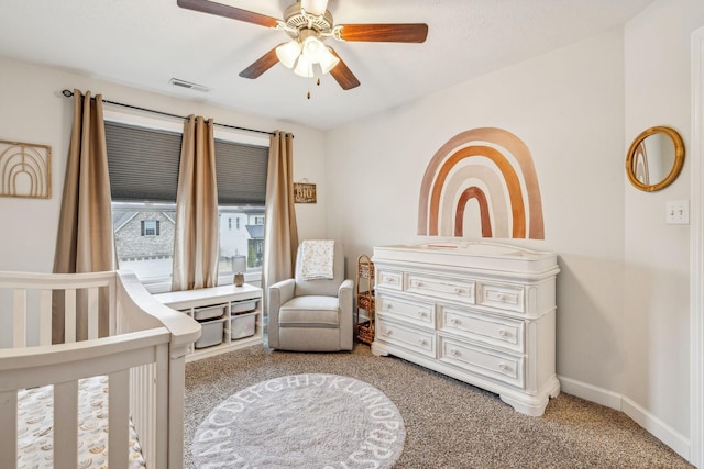 bedroom featuring ceiling fan, carpet flooring, visible vents, baseboards, and a nursery area