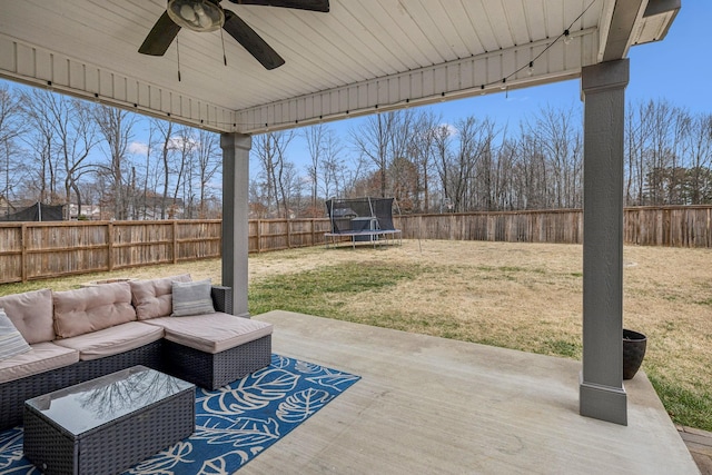 view of patio featuring a fenced backyard, a trampoline, outdoor lounge area, and a ceiling fan