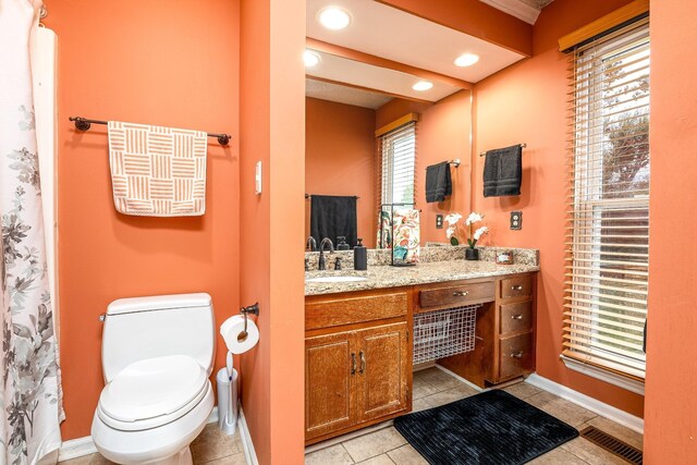 bathroom featuring visible vents, toilet, vanity, baseboards, and tile patterned floors