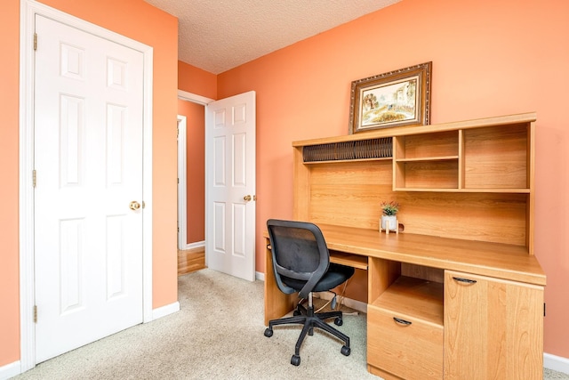 office with a textured ceiling, carpet, and baseboards