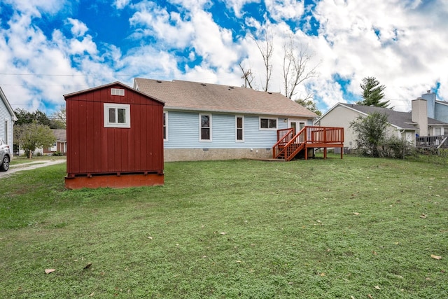 back of property with a deck, a yard, crawl space, and an outdoor structure