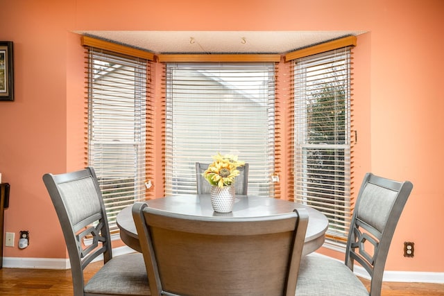 dining area with baseboards and wood finished floors