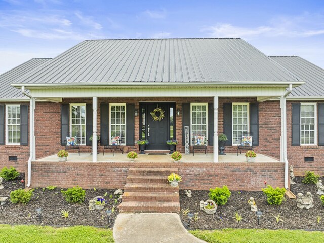 181 Hickory Grove Rd, Huntland, TN 37345 - view of front of house with a porch, brick siding, and metal roof