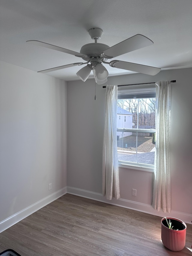 spare room with ceiling fan, baseboards, and wood finished floors