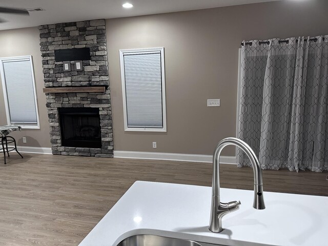 interior space featuring visible vents, a fireplace, baseboards, and wood finished floors