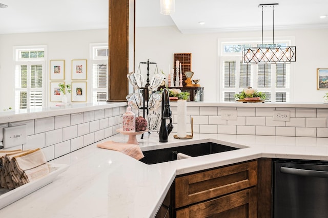 kitchen featuring dishwasher, decorative light fixtures, light stone countertops, dark brown cabinets, and backsplash