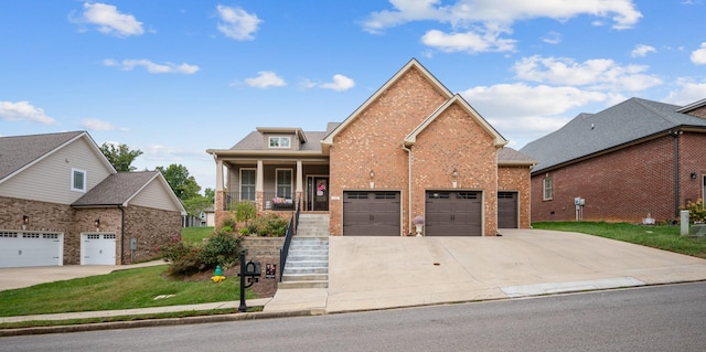 view of front of property with covered porch, driveway, brick siding, and stairs