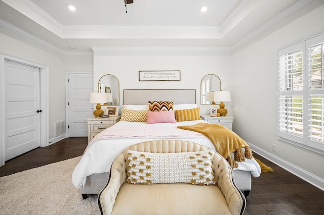 bedroom with recessed lighting, wood finished floors, baseboards, a raised ceiling, and crown molding