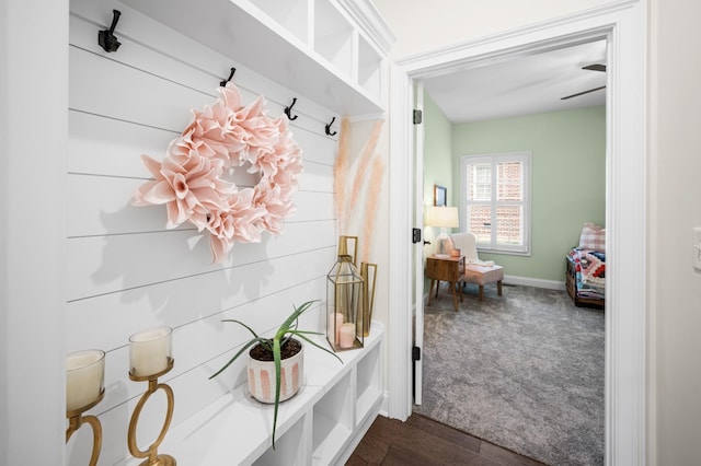 mudroom featuring baseboards and dark carpet