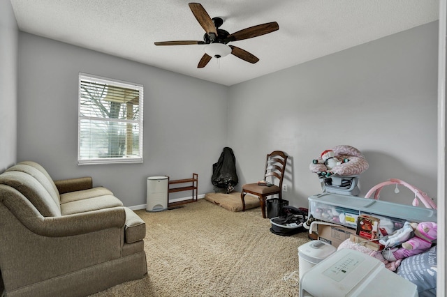 sitting room featuring carpet flooring, ceiling fan, a textured ceiling, and baseboards