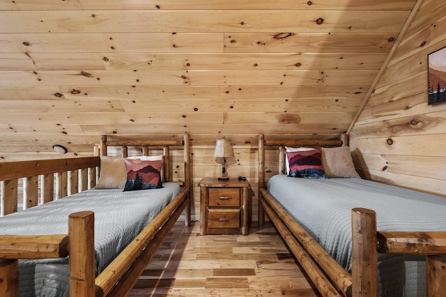 bedroom with lofted ceiling, light wood-type flooring, wooden ceiling, and wooden walls