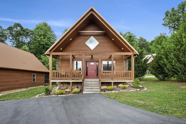 chalet / cabin featuring a porch and a front lawn