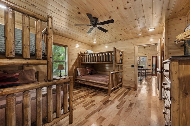 bedroom featuring light wood finished floors, wooden ceiling, and wooden walls