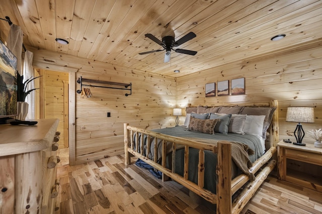 bedroom with wood ceiling, wooden walls, and light wood finished floors