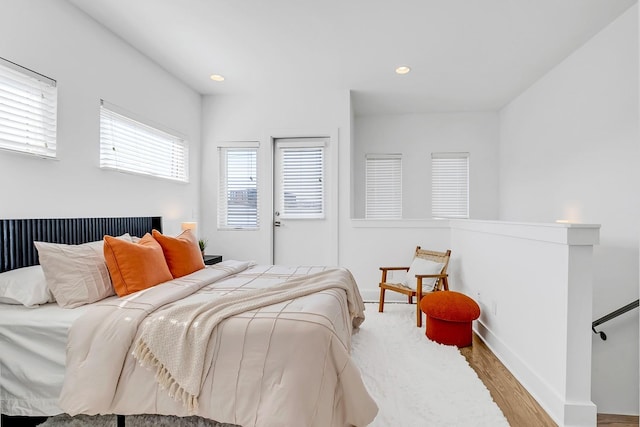 bedroom with baseboards, wood finished floors, and recessed lighting