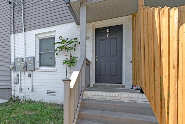 doorway to property with crawl space and brick siding