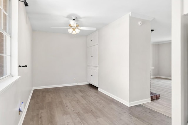 empty room with a ceiling fan, baseboards, and wood finished floors