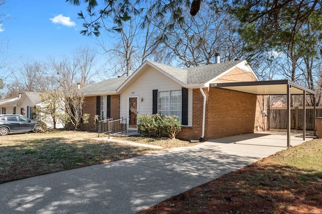 ranch-style house with a front yard, an attached carport, concrete driveway, and brick siding