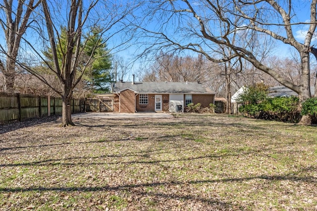 exterior space with brick siding, a front lawn, and fence