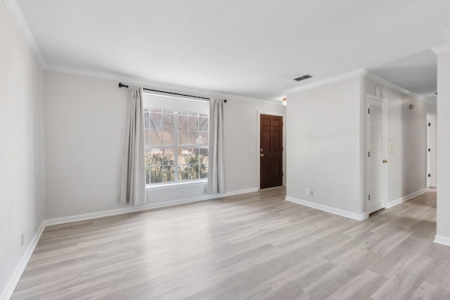 spare room featuring light wood-style floors, baseboards, visible vents, and crown molding