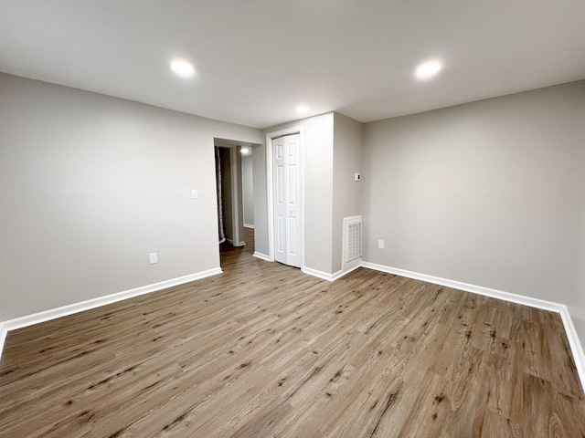 empty room featuring recessed lighting, visible vents, baseboards, and wood finished floors