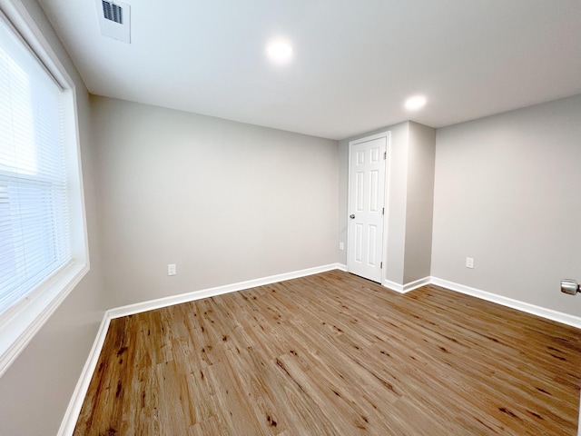 empty room featuring visible vents, baseboards, wood finished floors, and recessed lighting