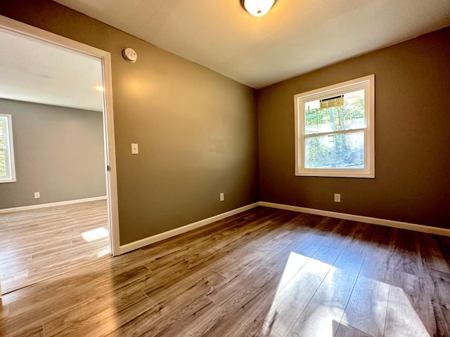 unfurnished room with wood finished floors and baseboards