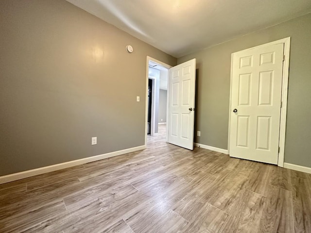 unfurnished bedroom featuring baseboards and wood finished floors