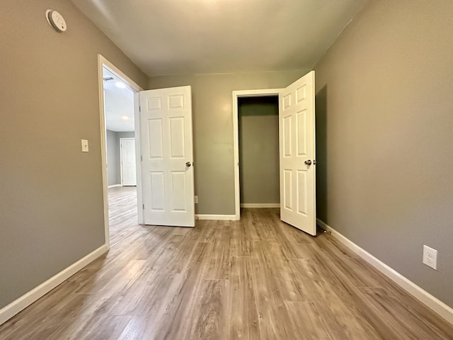 unfurnished bedroom with light wood-style floors and baseboards