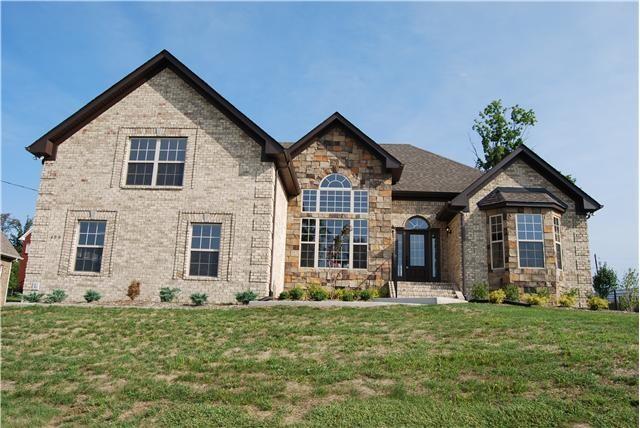 view of front facade featuring stone siding, brick siding, and a front yard