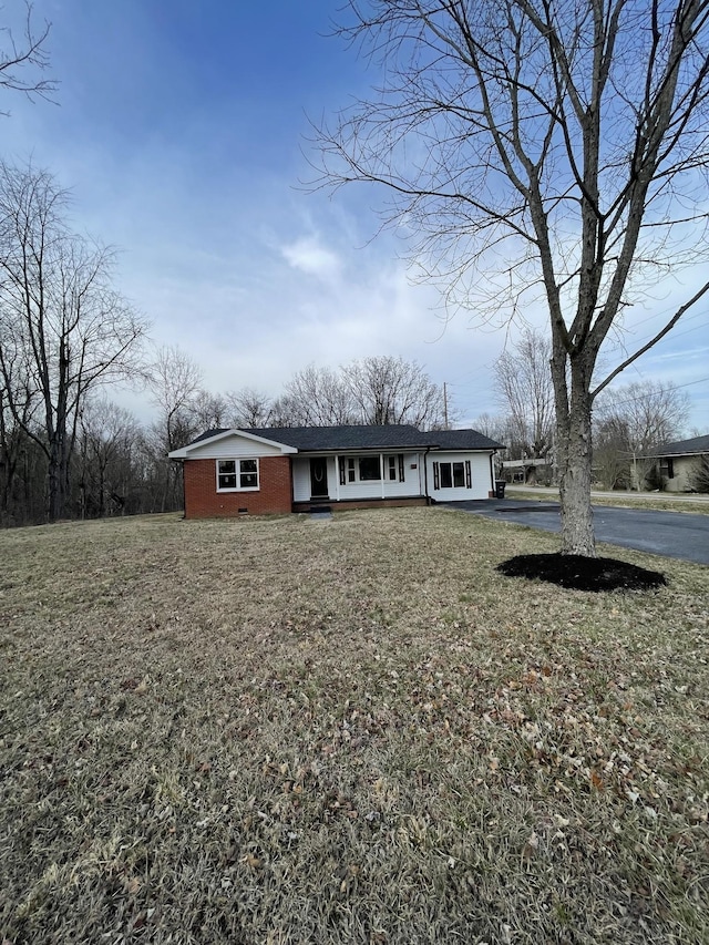 view of front of property featuring driveway, a front lawn, and brick siding