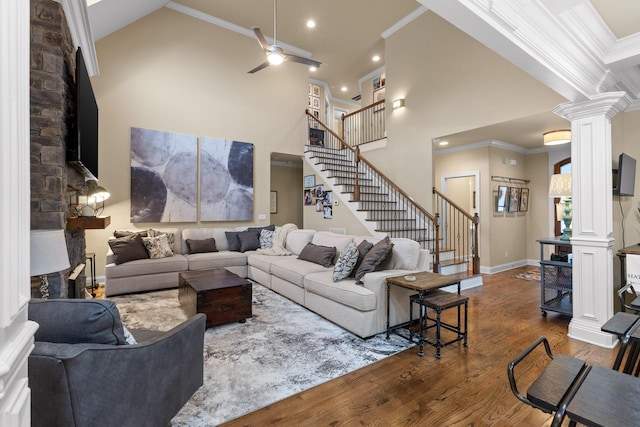 living area featuring ornamental molding, ornate columns, and wood finished floors