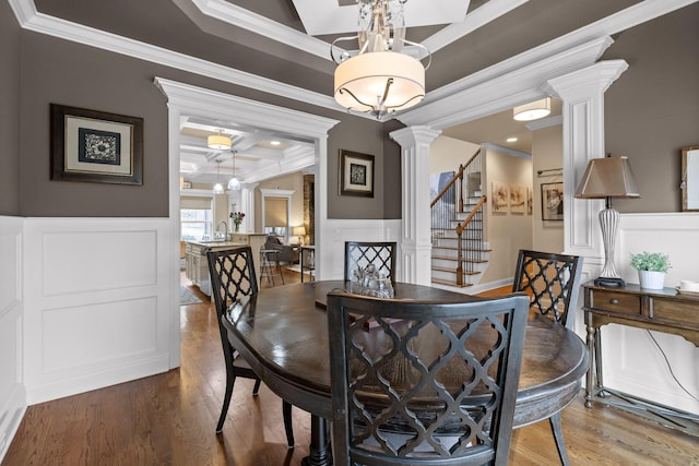 dining room featuring coffered ceiling, ornamental molding, stairs, ornate columns, and beam ceiling