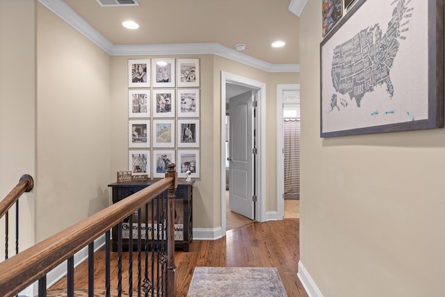 hallway with baseboards, crown molding, an upstairs landing, and wood finished floors