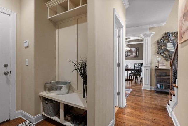 mudroom featuring baseboards, ornate columns, and wood finished floors