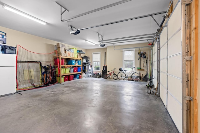 garage with a garage door opener and freestanding refrigerator