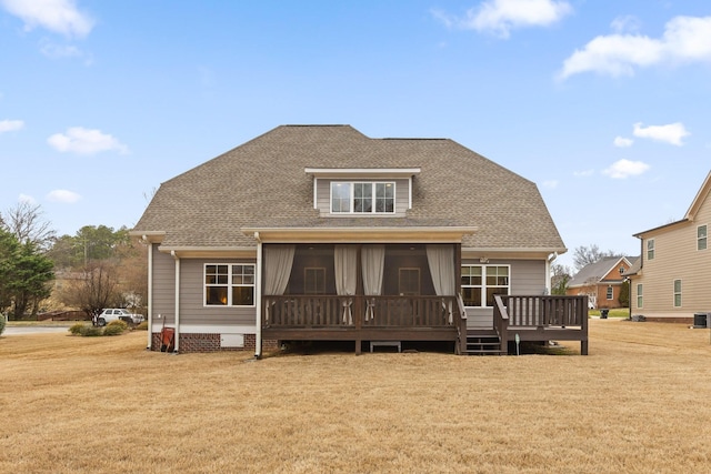 back of property featuring a shingled roof, a sunroom, and a yard