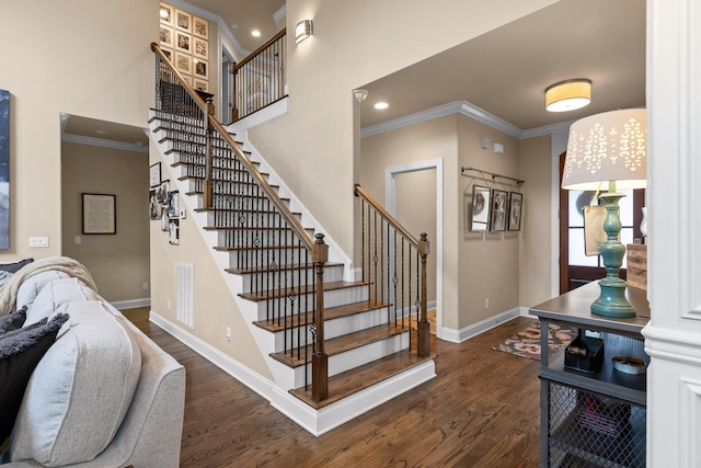 stairs with crown molding, baseboards, and wood finished floors