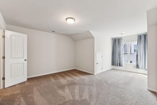 bonus room with baseboards, visible vents, vaulted ceiling, and carpet flooring