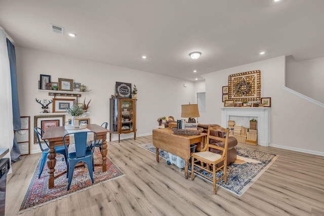 dining room with recessed lighting, baseboards, visible vents, and light wood finished floors