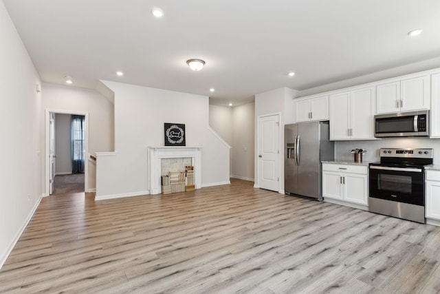 kitchen featuring appliances with stainless steel finishes, recessed lighting, white cabinets, and light wood-style floors