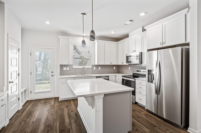 kitchen with appliances with stainless steel finishes, visible vents, a sink, and decorative backsplash