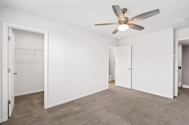 unfurnished bedroom with a spacious closet, carpet flooring, and baseboards